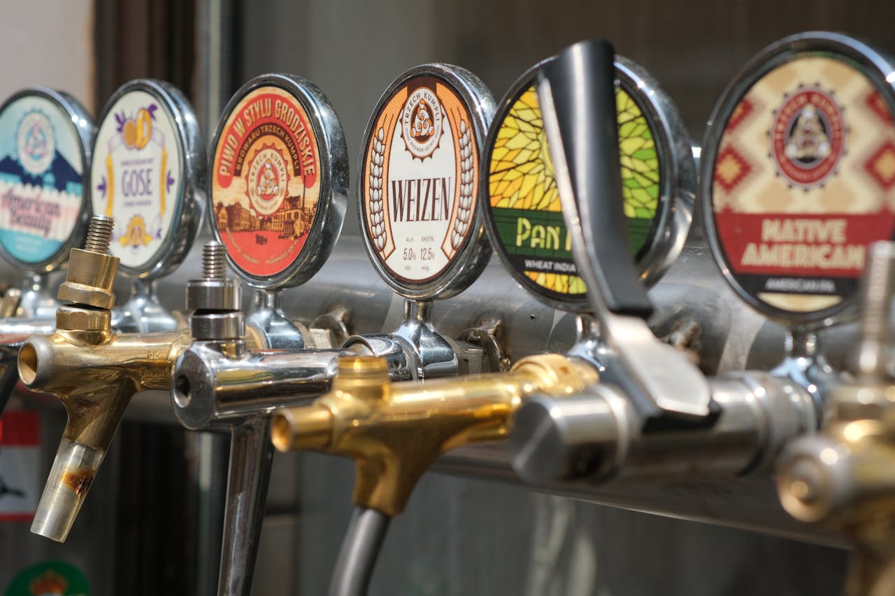 Close-up of craft beer taps with diverse labels in a bar setting. Ideal for beverages and brewery themes.