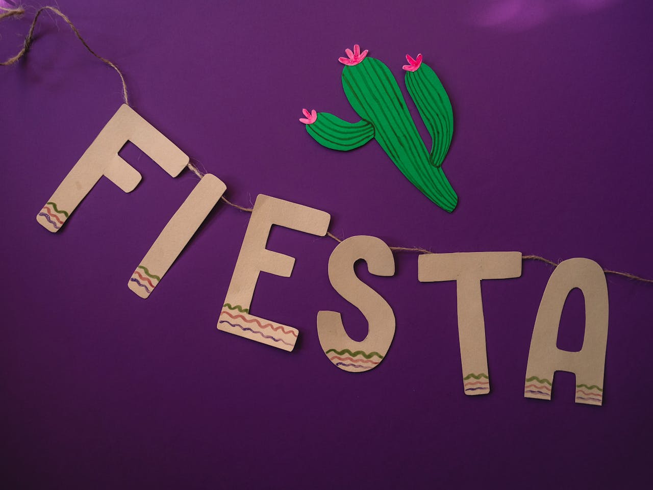 Creative fiesta celebration banner with cactus design on purple background for festive decorations.