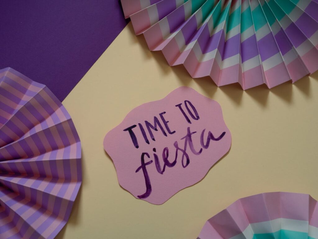 Vibrant paper decorations with 'Time to Fiesta' note in pastel colors, perfect for parties.